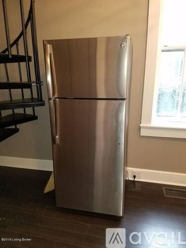 A stainless steel refrigerator in a room with a window.