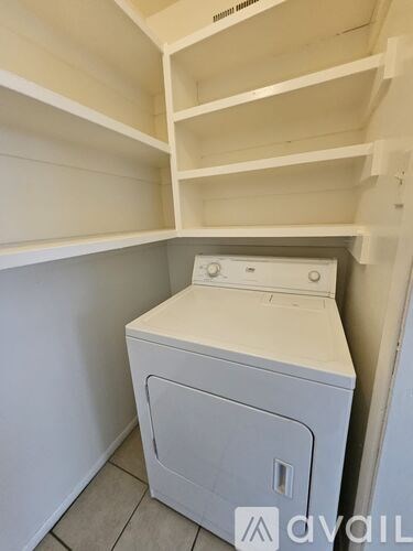A white washing machine is placed in a small laundry room.