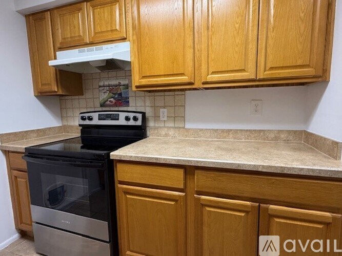 A kitchen with wooden cabinets and a black stove top oven.
