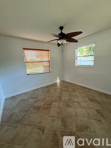 A room with a ceiling fan and tiled flooring.