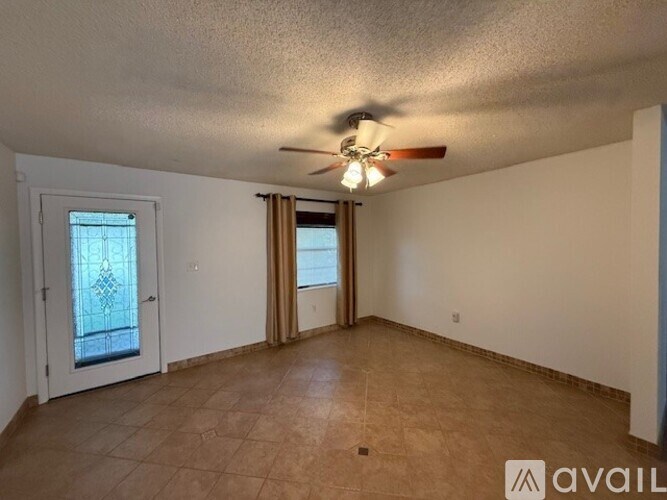 A room with a ceiling fan and a door leading to a balcony.