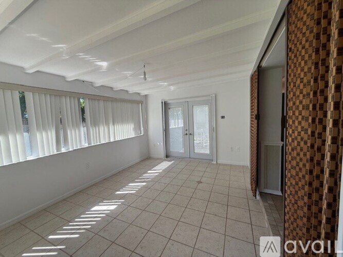 A room with tiled flooring and a checkered curtain.