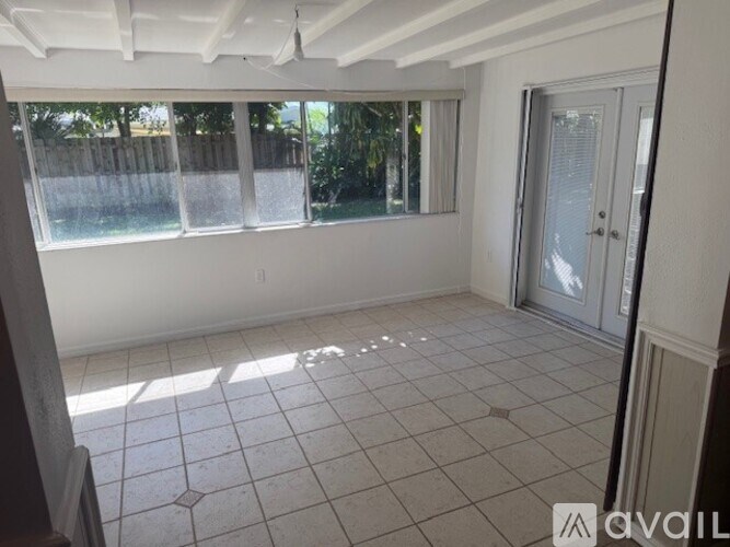 A room with a tiled floor and a sliding glass door leading to a backyard.