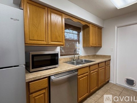 A kitchen with wooden cabinets and a white refrigerator.