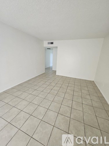 A room with tiled flooring and a doorway leading to another room.