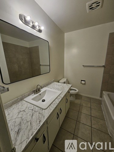 A bathroom with a marble countertop and a white sink.
