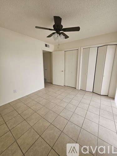 A room with a ceiling fan and tiled flooring.