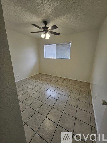 A room with a ceiling fan and a window.
