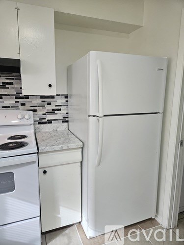 A white fridge in a kitchen with a white stove.