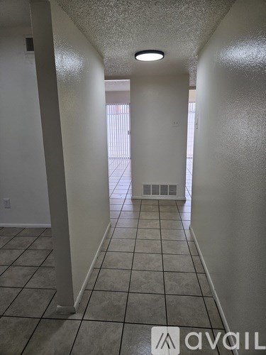 A long hallway with tiled floors and white walls.