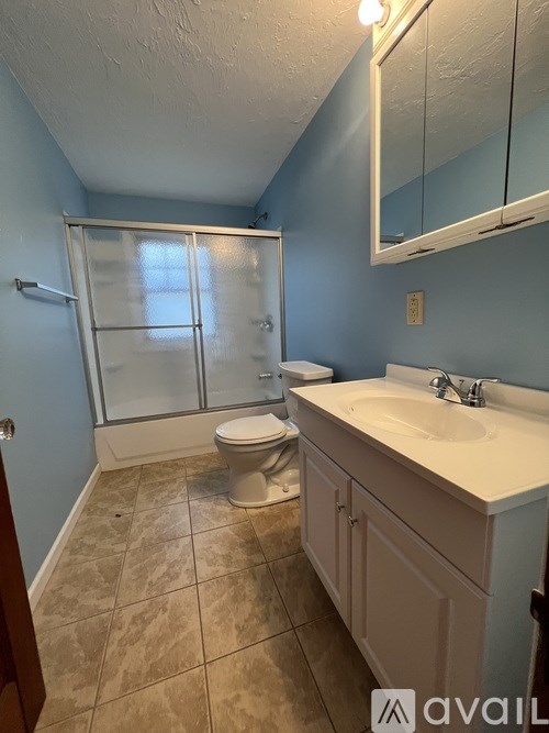 A bathroom with a toilet, sink, and shower.