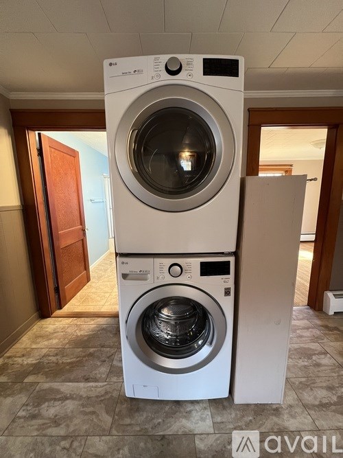 A white washing machine and dryer stacked on top of each other in a room.
