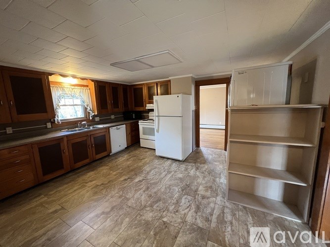 A kitchen with wooden cabinets and a white refrigerator.