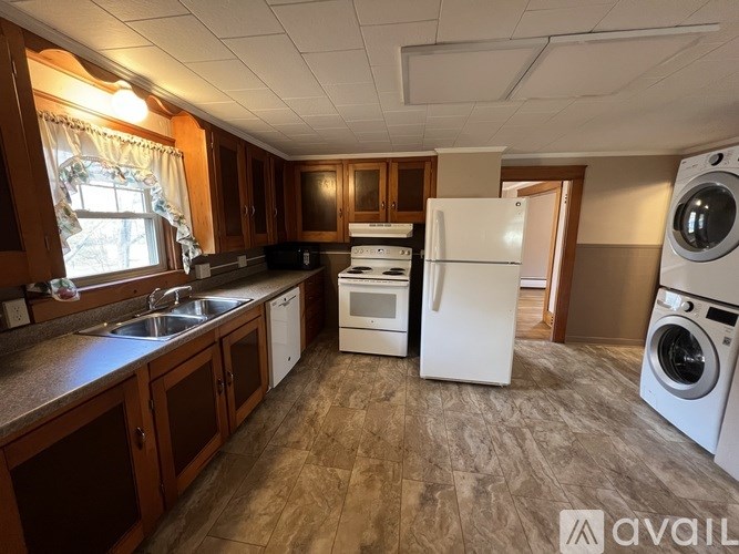 A kitchen with wooden cabinets and a white refrigerator.