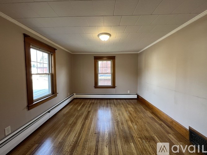 A room with wooden floors and two windows.
