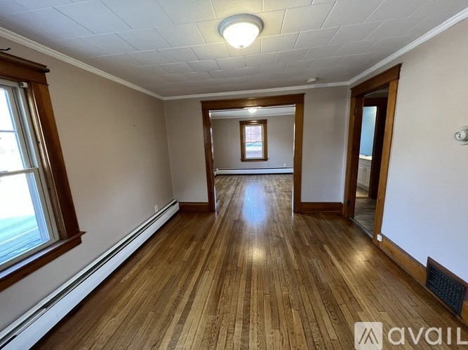 A room with wooden floors and a window on the left side.