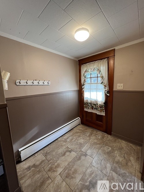 A room with a tiled floor and a window with a curtain.