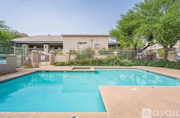 A pool in front of a building surrounded by a fence.