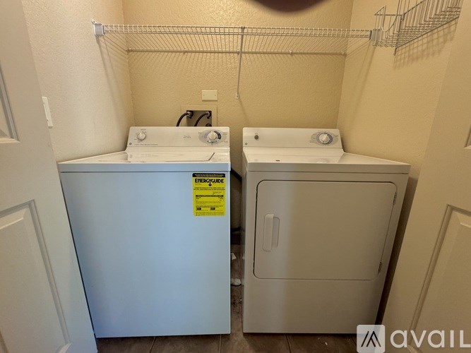 Two front loading washing machines in a small laundry room.