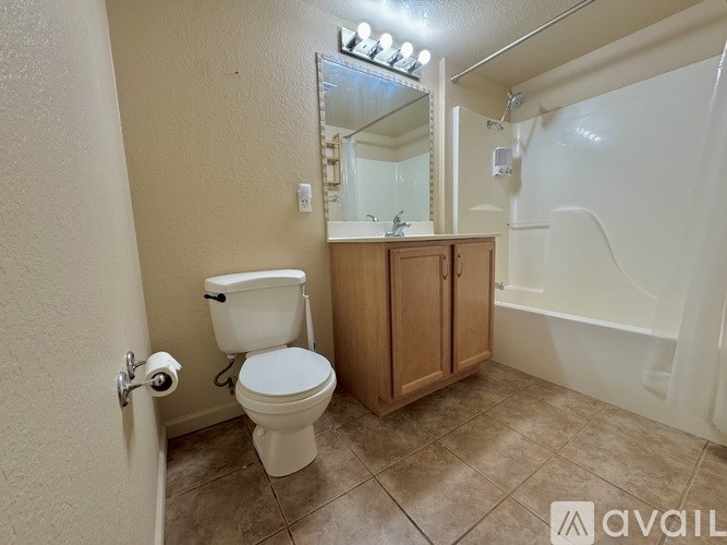 A bathroom with a toilet, sink, and mirror.