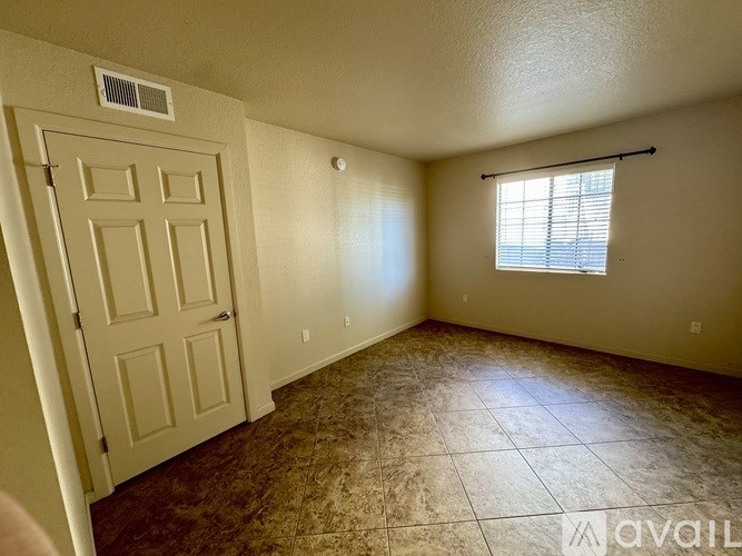 A room with a door, a window, and a tiled floor.