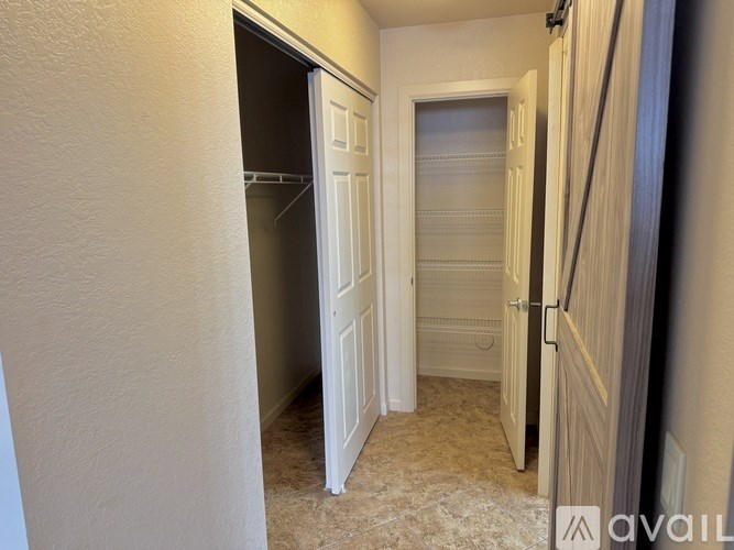A hallway with a white door and a carpeted floor.