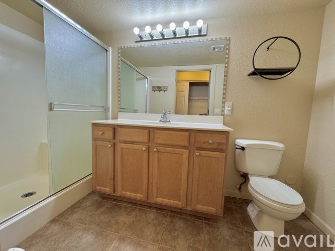 A bathroom with a wooden vanity and a toilet.