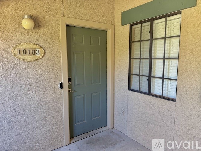 A green door with the number 10103 on the wall above it.