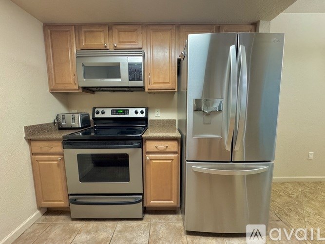 A kitchen with a stainless steel refrigerator and a stove with an oven.
