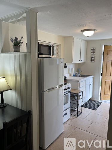 A kitchen with a white refrigerator and a black table.