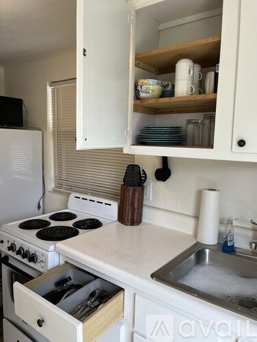 A kitchen with a white stove top oven and a white refrigerator.