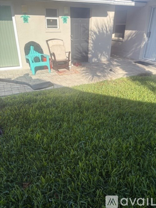A patio with a chair and table outside a house.