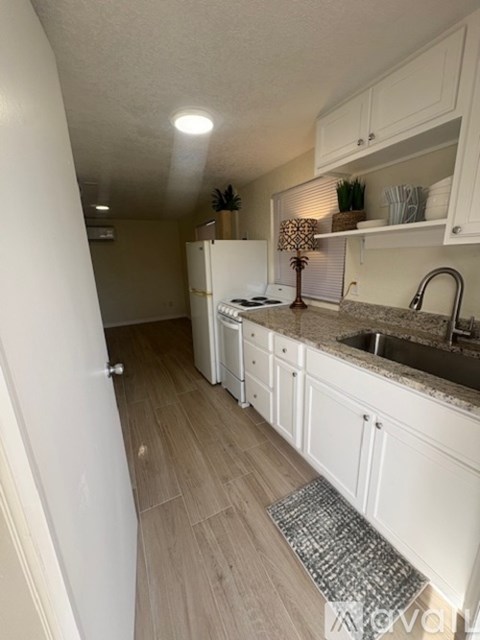 A kitchen with a table and chairs in the foreground and a refrigerator in the background.
