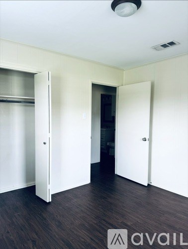 A room with a white door and a wooden floor.