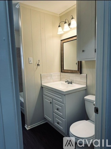 A bathroom with a white sink and toilet.