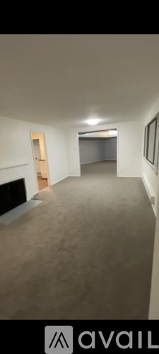 A room with a carpeted floor and a door on the left side.