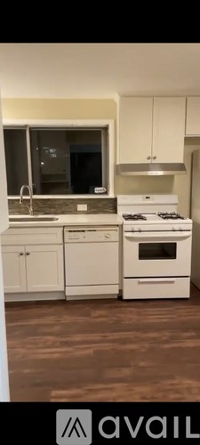 A modern kitchen with white appliances and cabinets.