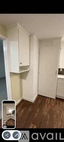 A white cabinet is mounted on a wall in a room.