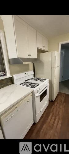A kitchen with white appliances and cabinets.