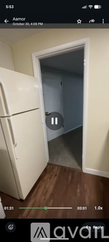 A black cat is sitting in the doorway of a room.