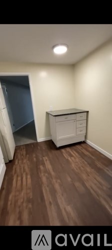 A room with a wooden floor and a white cabinet.