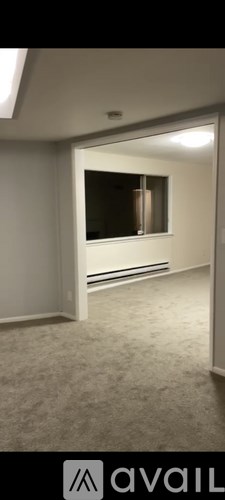 A room with a carpeted floor and a window.