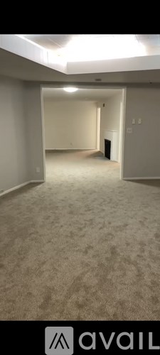 A spacious room with carpeted floor and white walls.