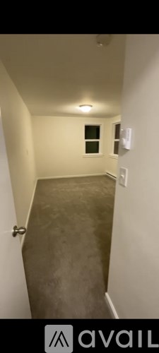 A hallway with a door on the left and a window on the right.