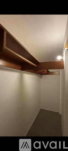 A room with a white wall and a brown ceiling.