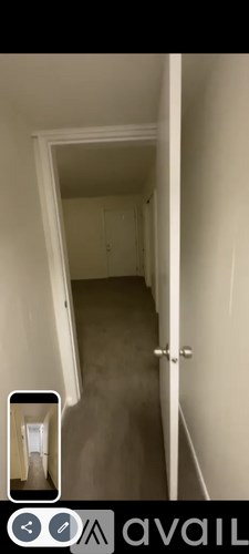 A hallway with a door on the right and a small window on the left.