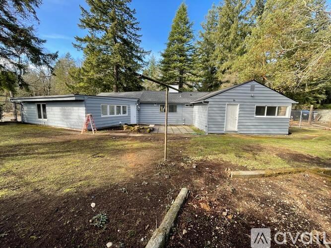 Two houses are situated in a grassy area with trees in the background.