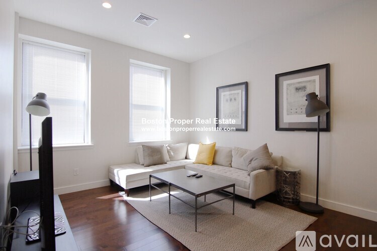 A living room with a couch, coffee table, and two framed pictures on the wall.