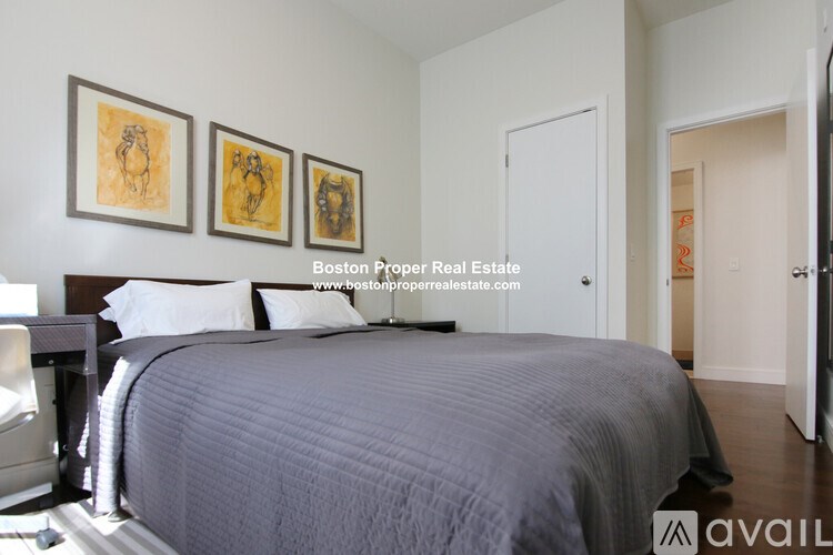 A bedroom with a bed, a chair, and three pictures on the wall.