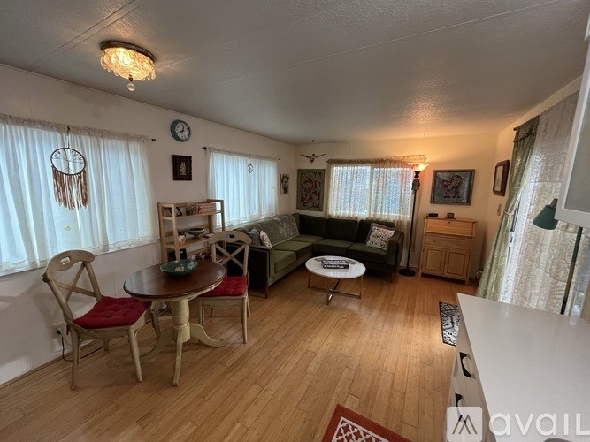 A living room with a couch, chairs, and a table.